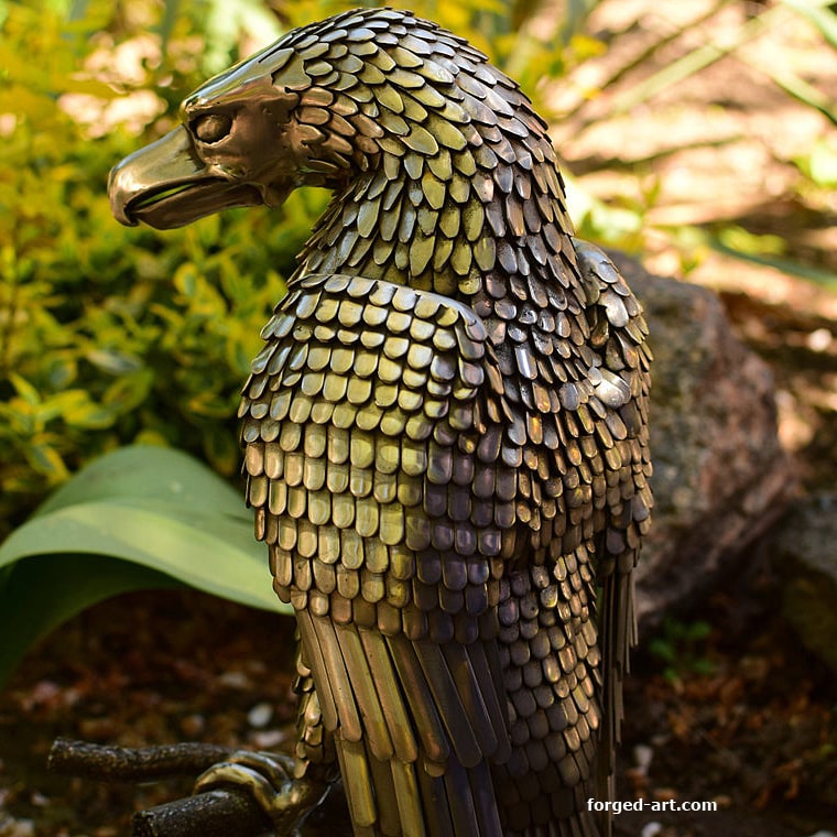 An eagle sitting on a tree - a beautiful sculpture made of stainless steel